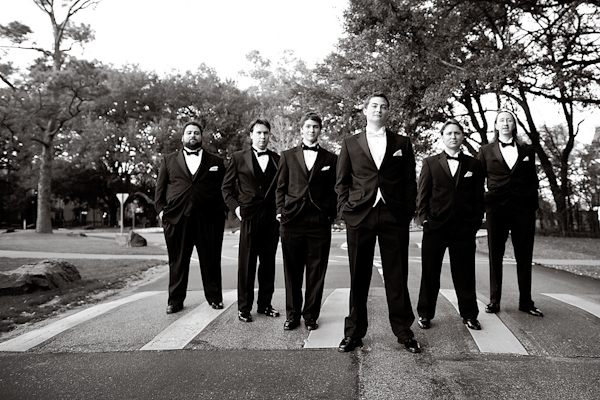 grooms and groomsmen outside on crosswalk - hands in pockets -black and white- photo by Houston based wedding photographer Adam Nyholt